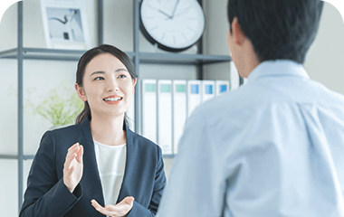 オフィス内で会話する男女の写真